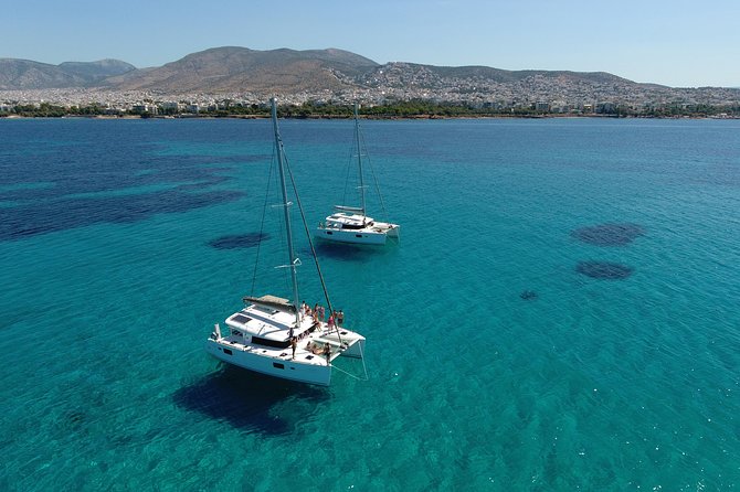 Athens Private Luxury Catamaran Cruise with Traditional Greek Meal and BBQ - First swimming stop with towels and sea views