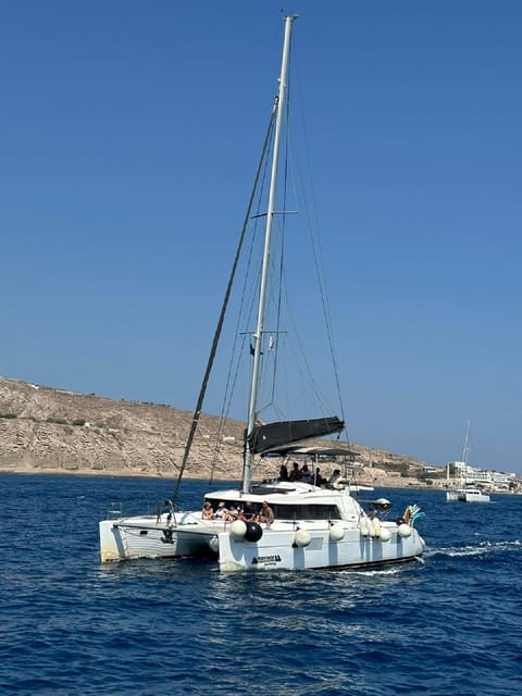 Santorini:Cruises with Catamaran around the Volcanic Island. - White Beach, the lighthouse, and Black Mountain