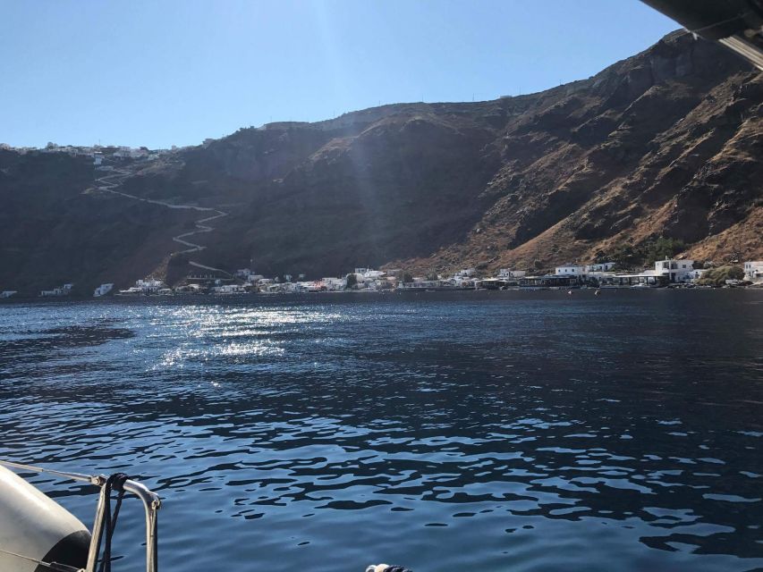 Santorini: Private 5-Hour Sunset Sailing Tour with Dinner - Entering the caldera beneath the lighthouse
